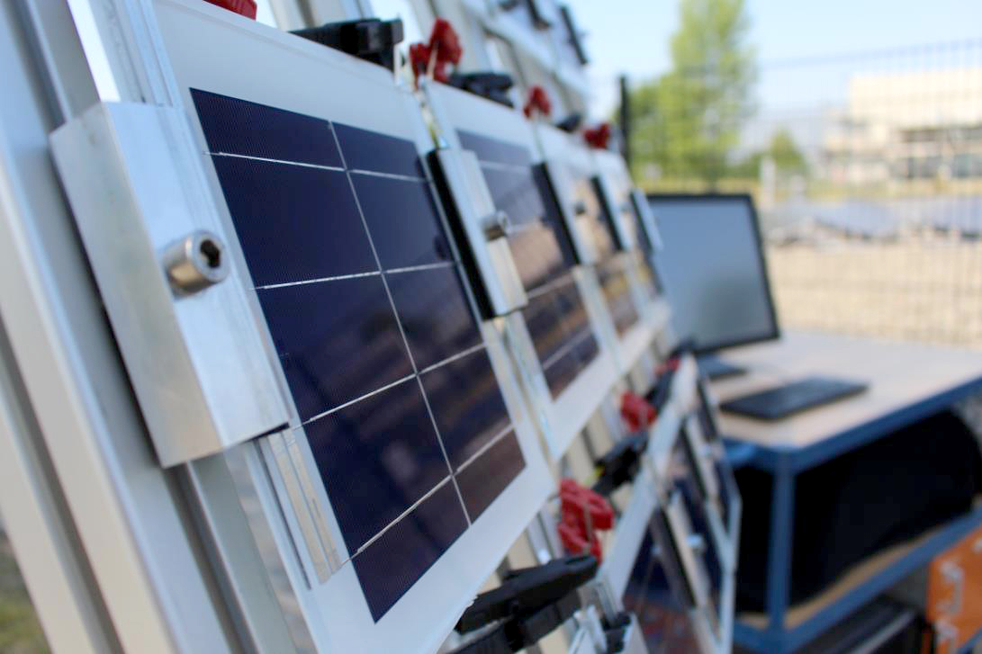 Outdoor measurement setup of the Bill of Materials Tester with up to 16 mini modules on a test frame, equipped with precise measurement electronics for simultaneous I-V analysis under identical conditions